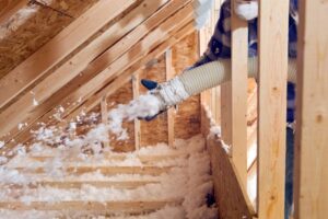Man spraying foam insulation for better home heating efficiency.