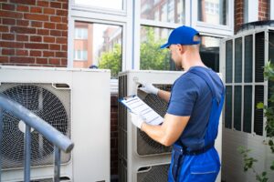 air-conditioner-technician-inspecting-outdoor-unit